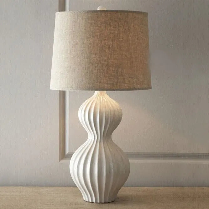 American country style ceramic table lamp with a white fabric shade, shown on a wooden table.