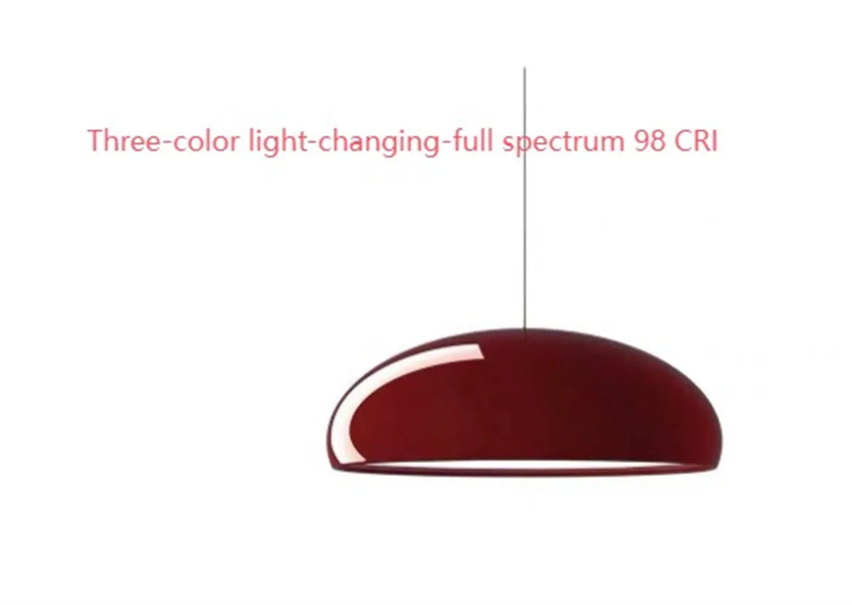 Danish-style iron pendant lamp with adjustable cord above a restaurant table.