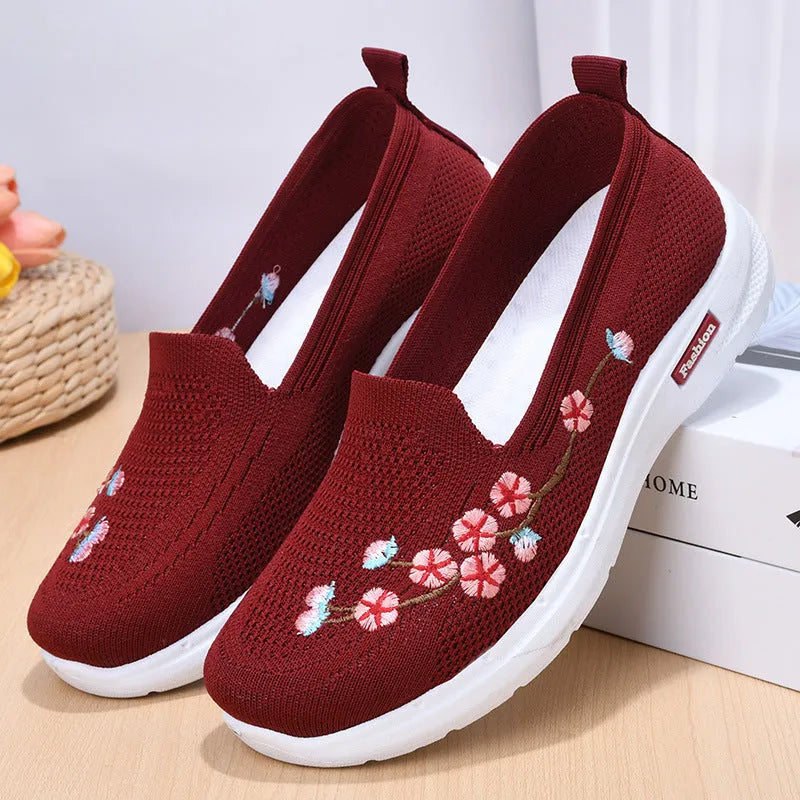 Women's wine red embroidered low heel pumps with round toe and anti-slip sole.