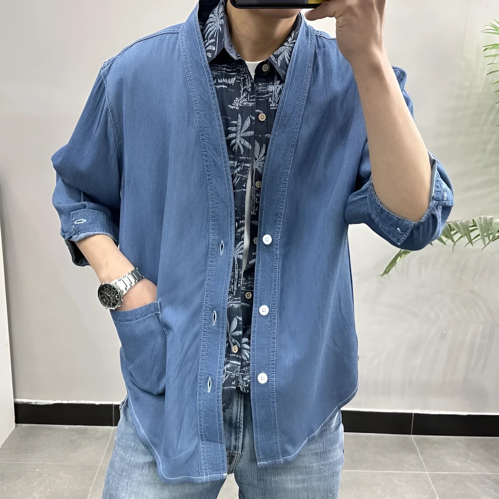 Men's dark blue three-quarter sleeve V-neck casual denim coat laid flat.