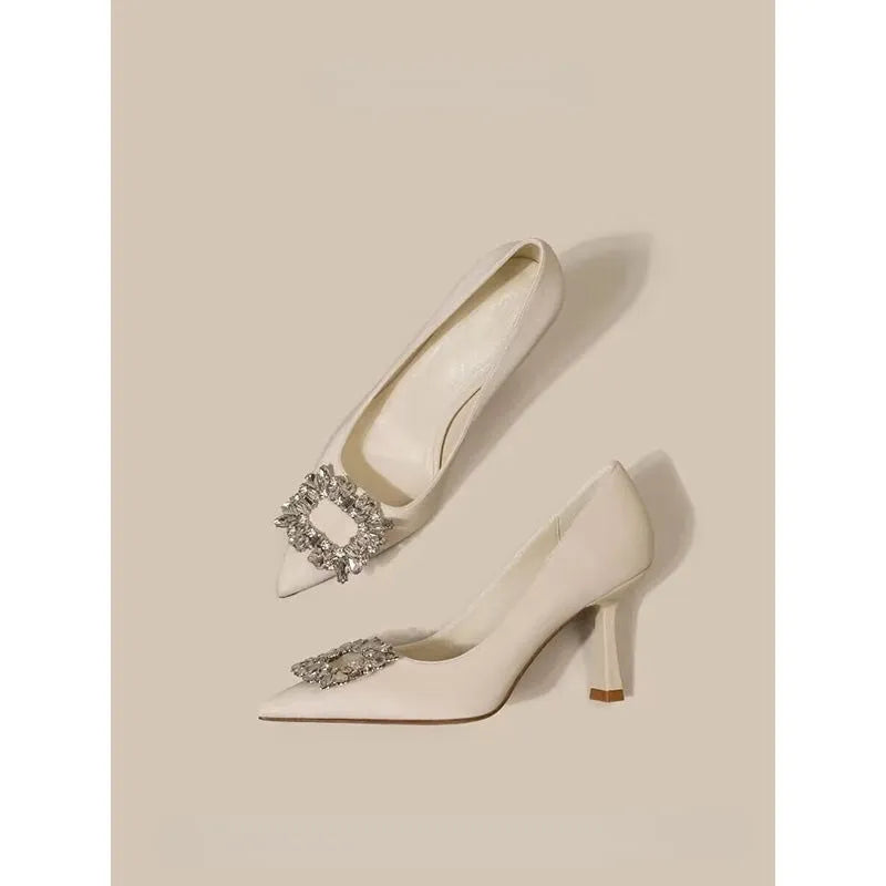 Women's creamy-white pointed toe stiletto high heel pumps for formal wear.