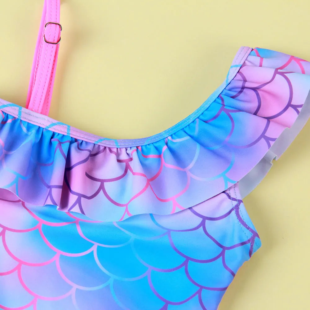 Girls' one-piece swimsuit with cartoon scale print and flounced gradient design in high elasticity nylon.