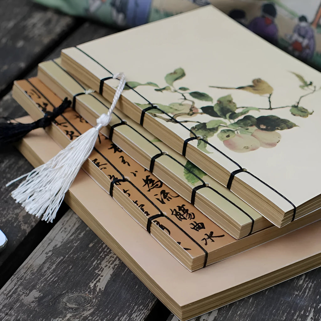 Antique wire-bound notebook with historical artwork cover and decorative tassels