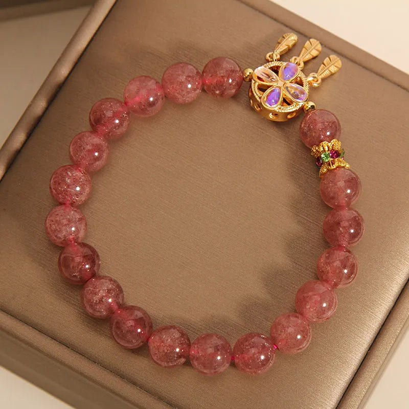 Women's strawberry quartz bracelet with a four-leaf clover dream catcher ball pendant.