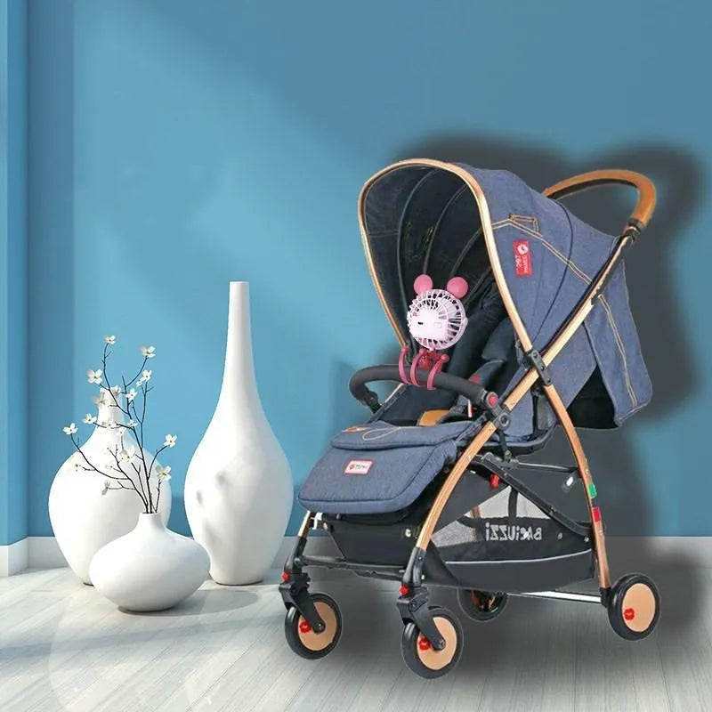 Pink portable USB rechargeable fan with animal design and clip attached to a stroller handle.