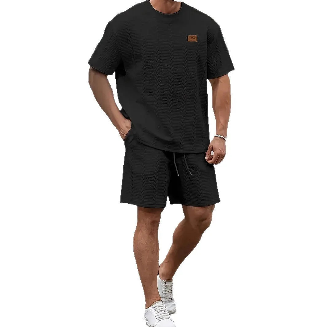 Men's black sports two-piece set with ribbed short sleeve top and matching trousers for athletic activities