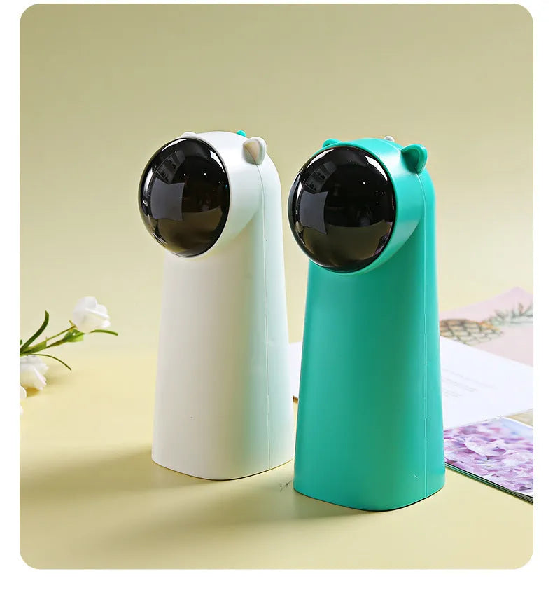 Automatic laser cat pole toy showing green with white plastic housing and LED red laser beam on floor