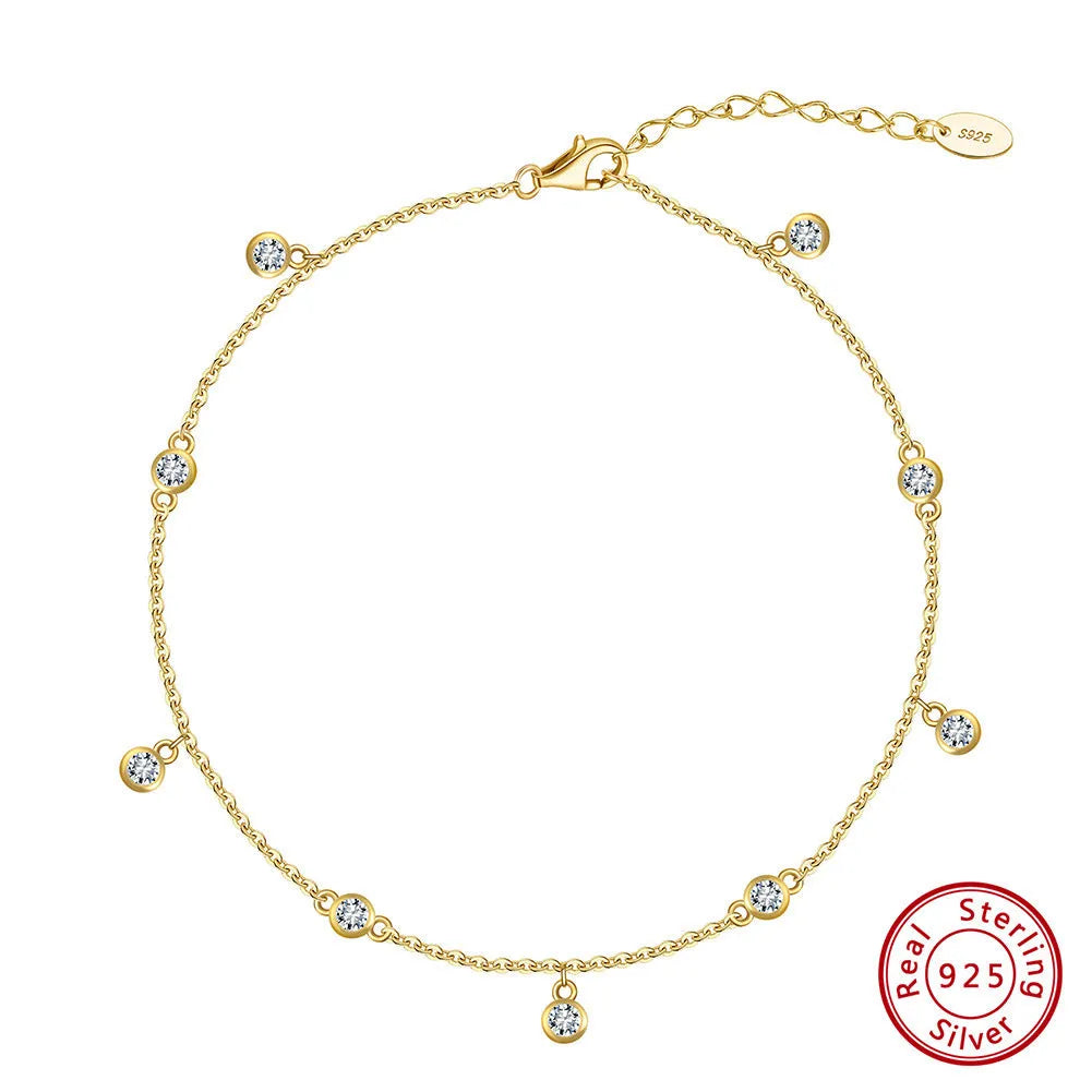 Close-up of a women's geometric zirconium pendant anklet on a sterling silver chain.