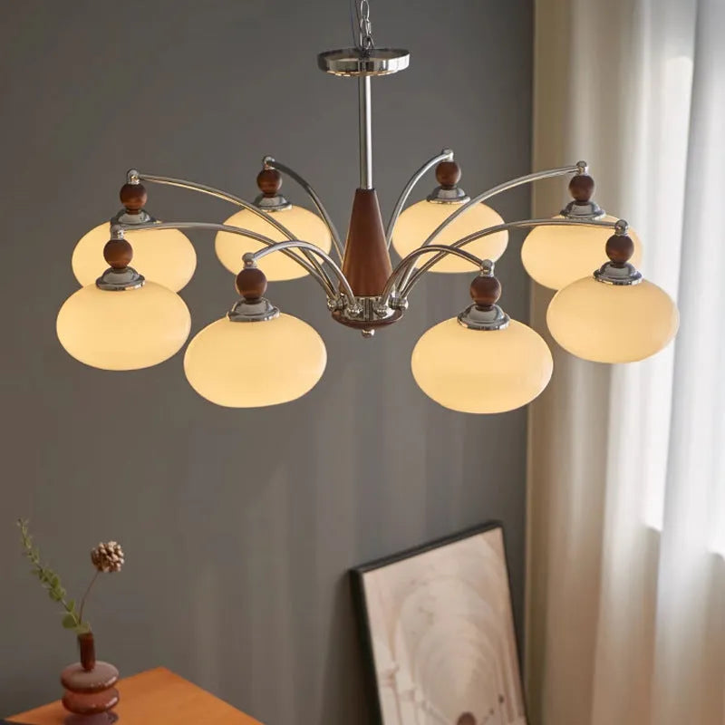 Traditional persimmon glass chandelier with multiple chrome arms and white glass lampshades hanging from a ceiling.