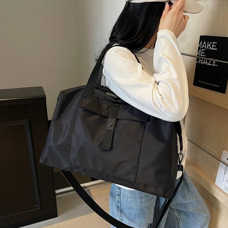 Large one-shoulder travel bag in Oxford cloth showing black, grey, and green colour options.