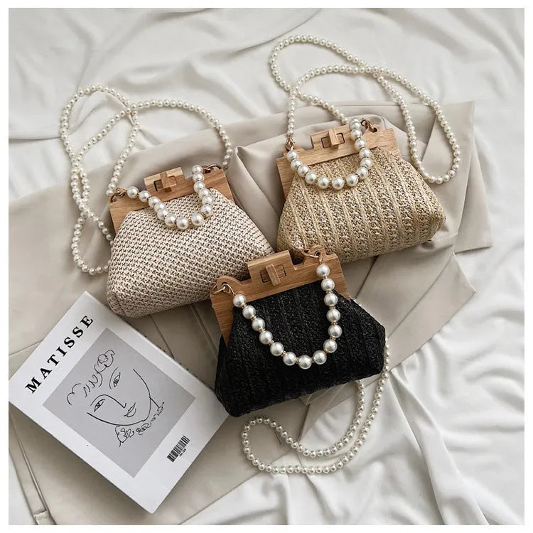 Women's woven straw shoulder bag with pearl chain strap showing internal organisation compartments