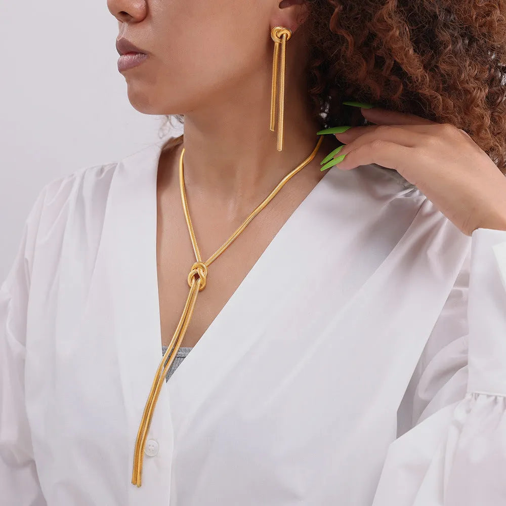Women's gold knotted tassel necklace on snake chain with matching titanium steel earrings