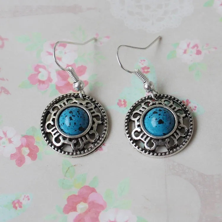 Handmade Miao silver ethnic earrings with turquoise on a retro flower disk design.