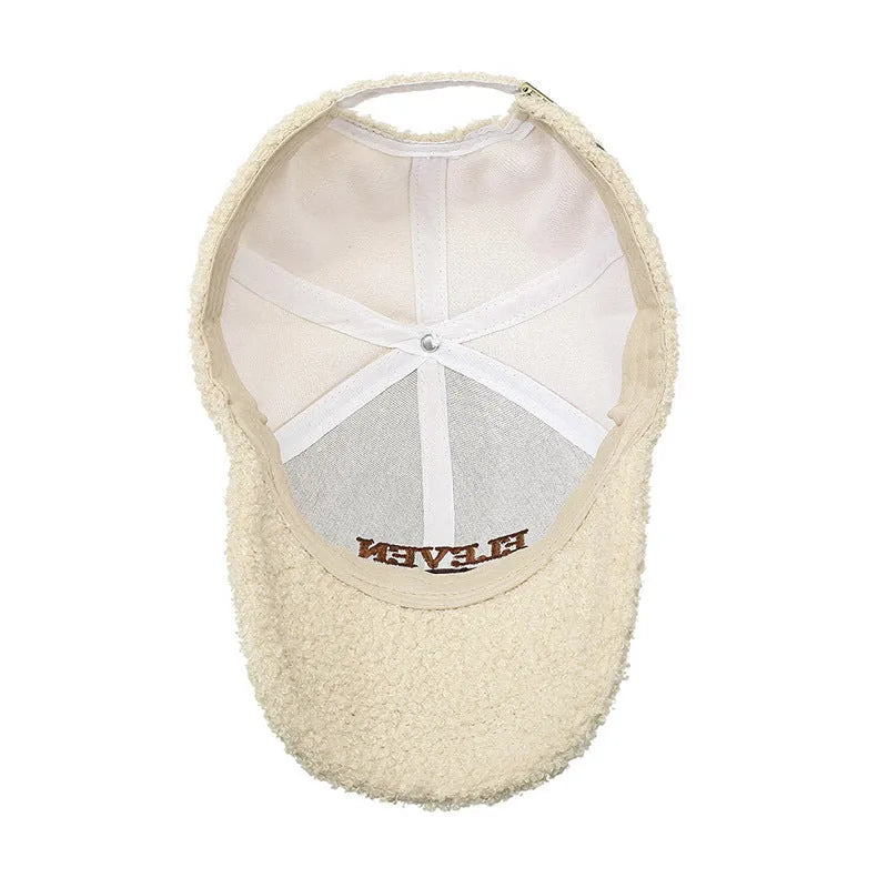 Adjustable lambskin winter baseball cap in black with dome crown and machine embroidery detail.