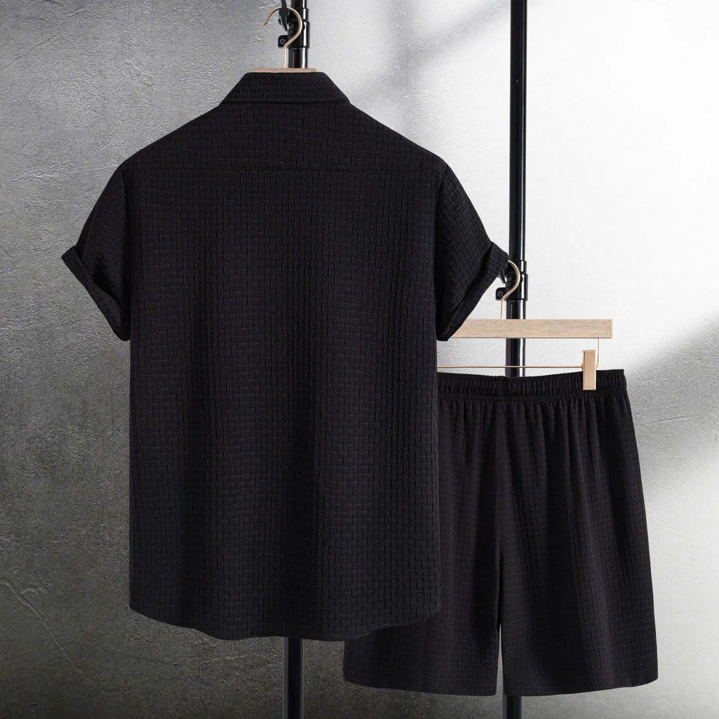 Men's loose fit cotton blend beach shorts suit in black, showing short sleeve shirt and matching shorts.