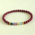 Purple gold cinnabar crystal bead bracelet on wrist showing handcrafted string construction