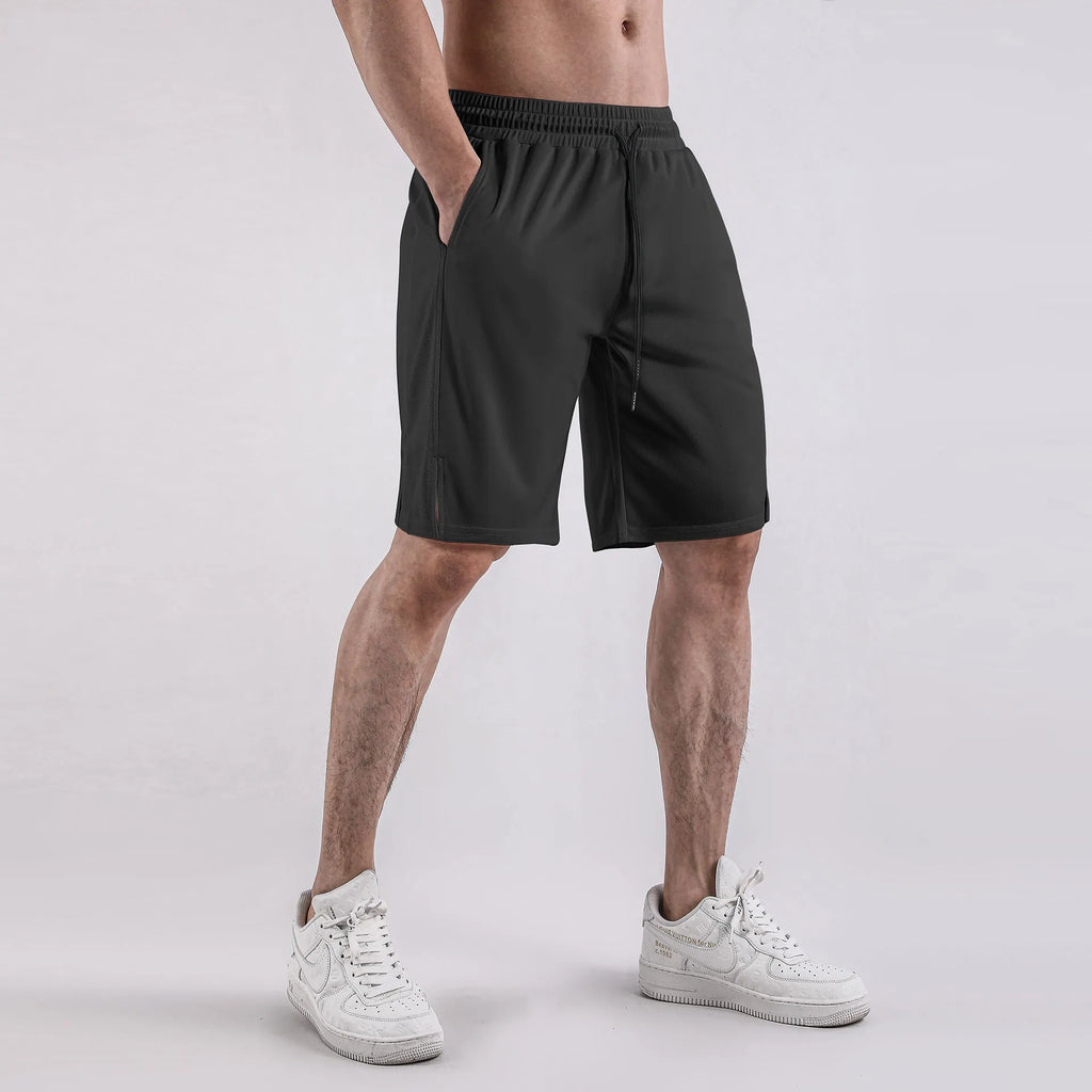 Man wearing loose-fit black quick-dry mesh shorts for casual summer sportswear.