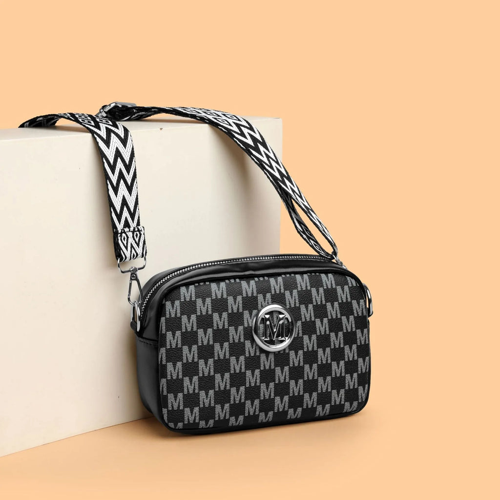 Crossbody bag with wide shoulder strap showing three-dimensional front pocket organisation