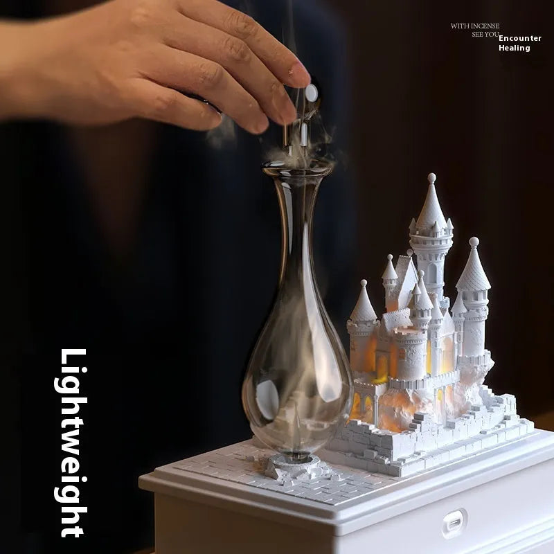 White medieval castle-shaped waterless aromatherapy machine with ambient light on a surface