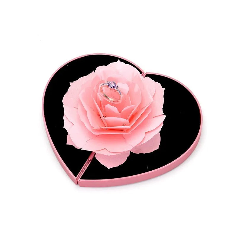 Red heart-shaped plastic ring box with a rose design and rotating 3D love text in the centre.