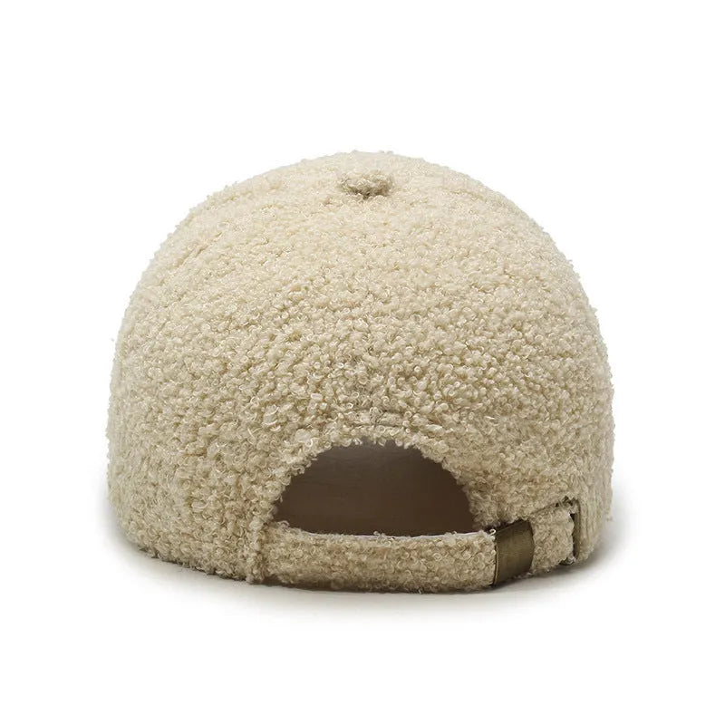 Adjustable lambskin winter baseball cap in black with dome crown and machine embroidery detail.