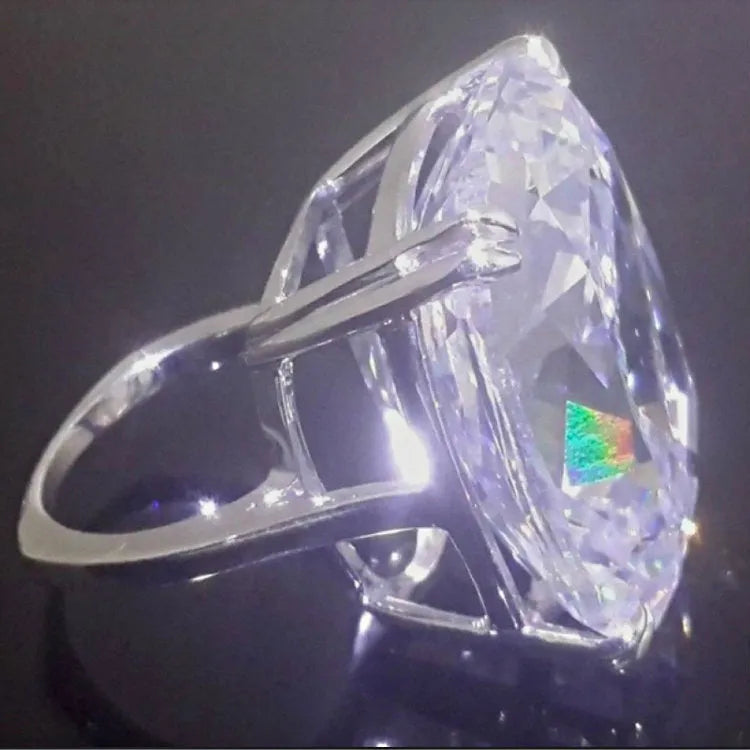 Simple women's alloy ring with an inlaid square diamond design in white gold colour on a model's finger.