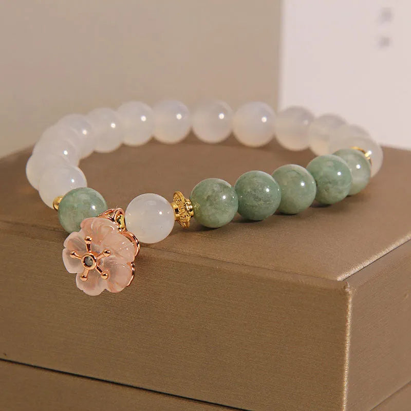 White agate floral bracelet with jade details and adjustable clasp on woman's wrist