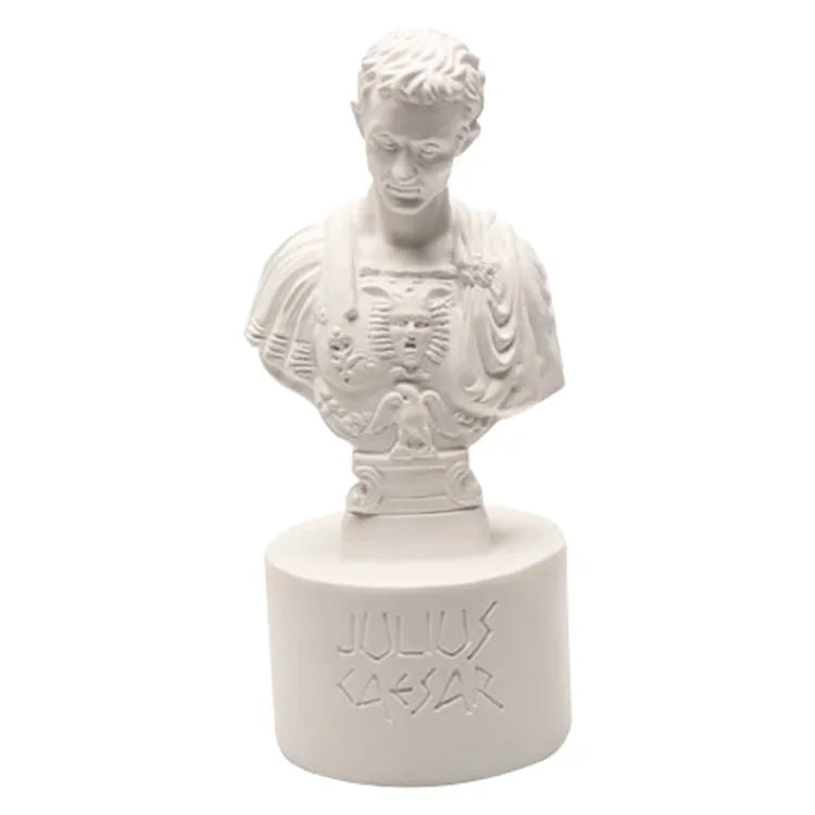 White resin sculpted character pen holder on a desk, holding pens and pencils.