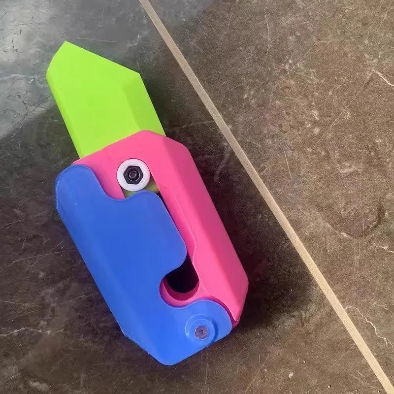 3D printed plastic gravity carrot knife fidget toy in orange, purple, and green colours.