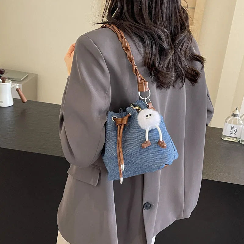Blue one-shoulder cross body bucket bag with sandwich pocket design and messenger styling