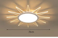 Modern round aluminium LED ceiling lamp with remote control on a white ceiling.