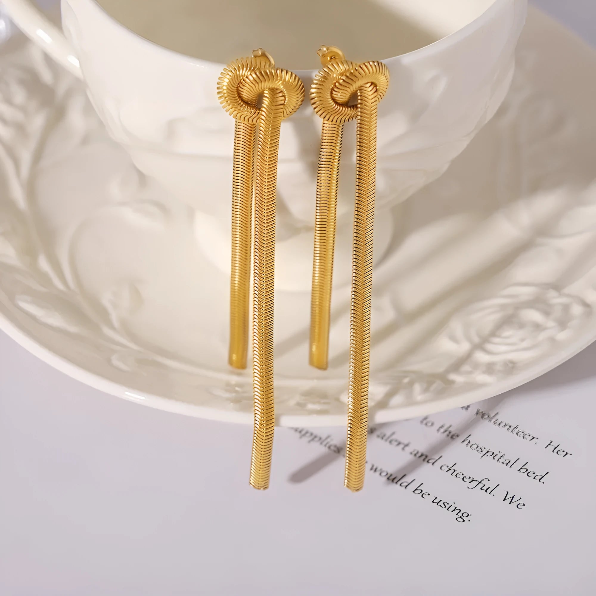 Women's gold knotted tassel necklace on snake chain with matching titanium steel earrings