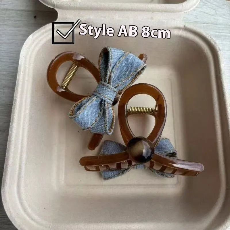 Denim blue bow hair barrette for women with metal clip, shown as a cloth bow hair accessory