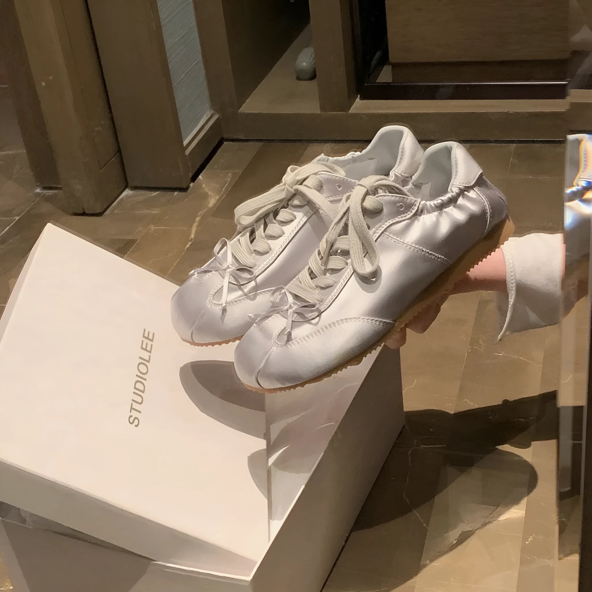 Women's silver grey satin ballet flat shoes with front lace-up design and round toe.