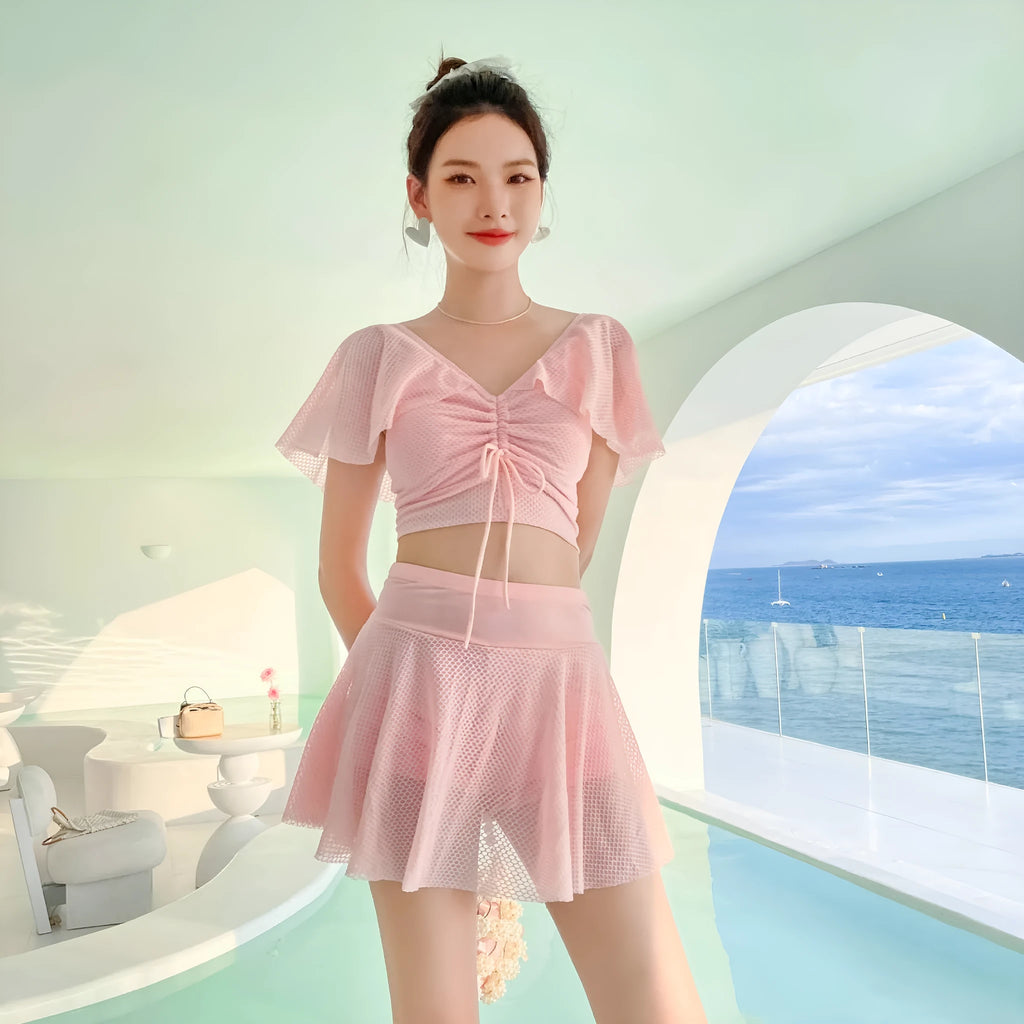 Women's solid colour two-piece swimsuit with a skirt, shown in white, black, and pink.