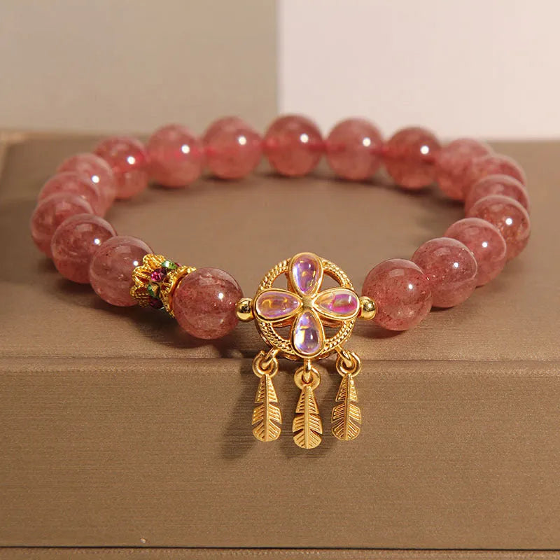 Women's strawberry quartz bracelet with a four-leaf clover dream catcher ball pendant.