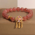 Women's strawberry quartz bracelet with a four-leaf clover dream catcher ball pendant.