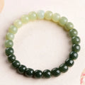 Natural Hetian jade bracelet with sunny water gradient colour on a wrist, showing oval beads.