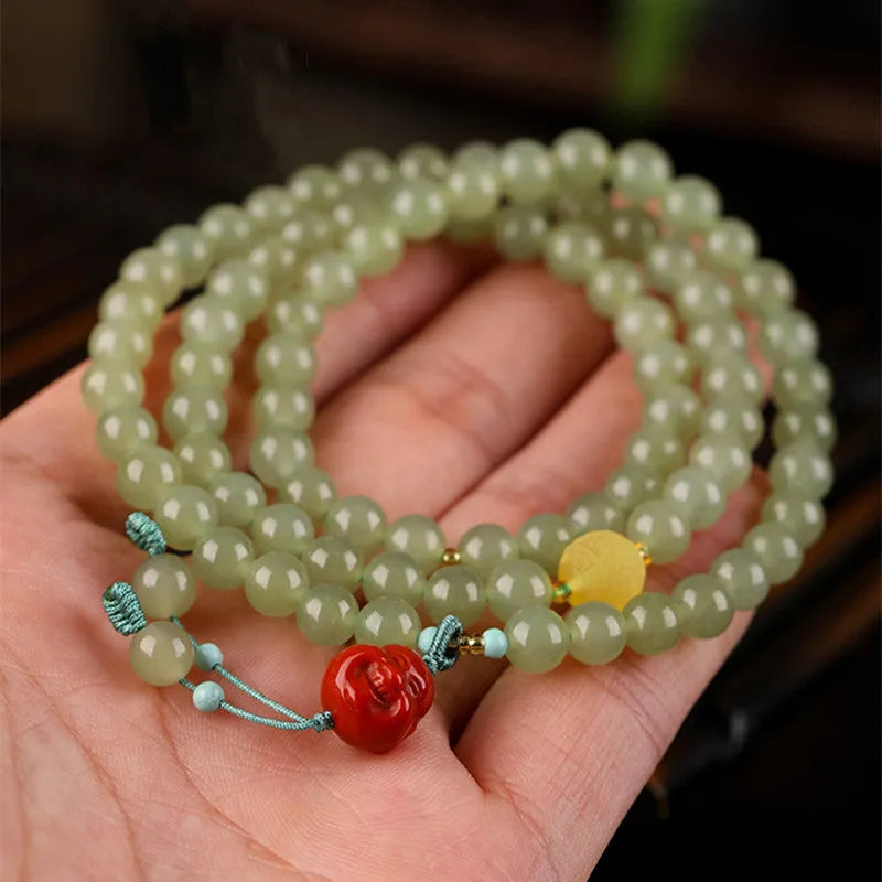 Pale blue Hetian jade bracelet with three circles of 6mm beads on a wrist.