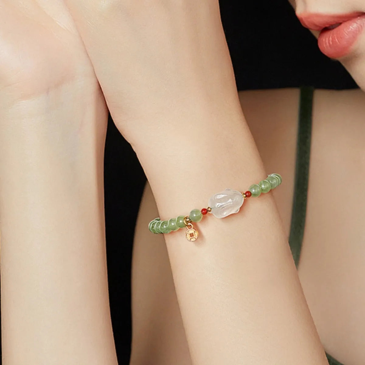 Close-up of a women's handmade bracelet with a detailed jade rabbit charm in a gift box.