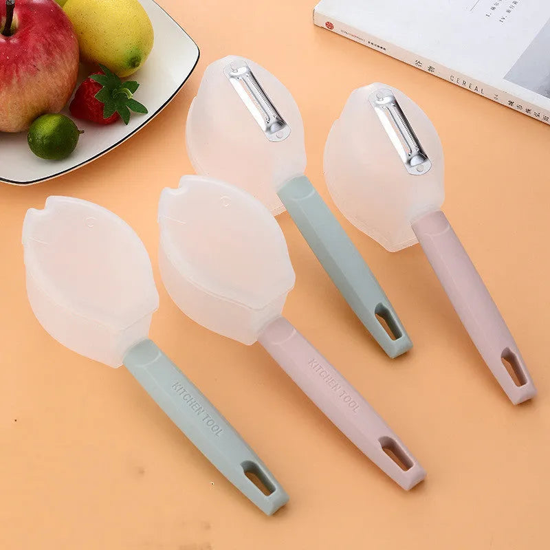 Stainless steel fruit peeler with pink PP plastic handle on a light background