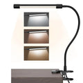 Black and white USB-powered LED desk lamp with a 26 cm long base on a wooden desk.