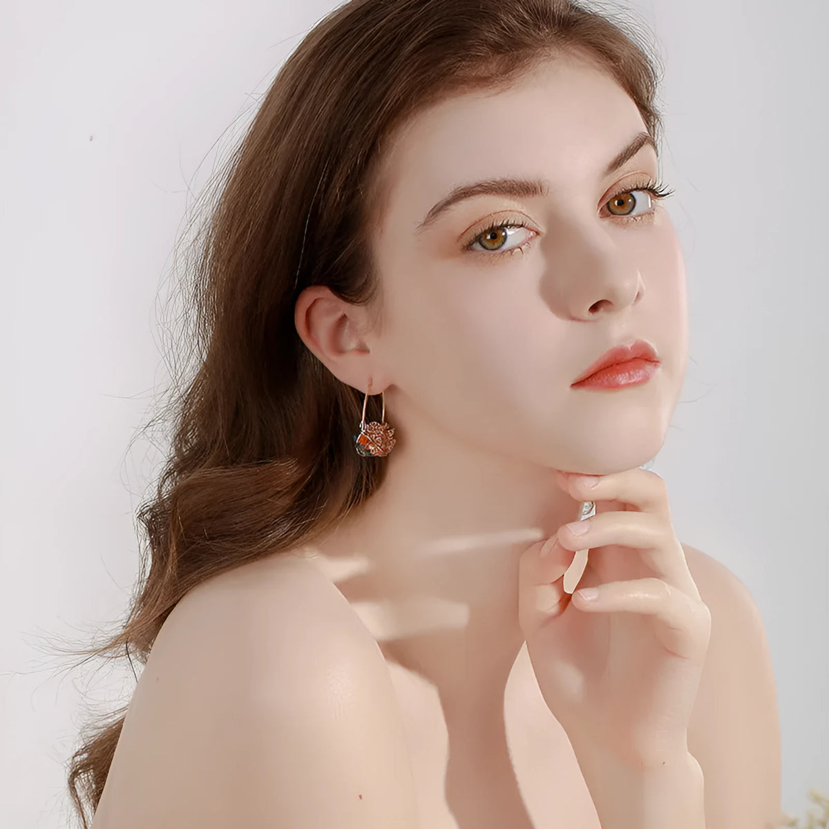 Pair of champagne gold geometric quadrilateral drop earrings on a neutral background
