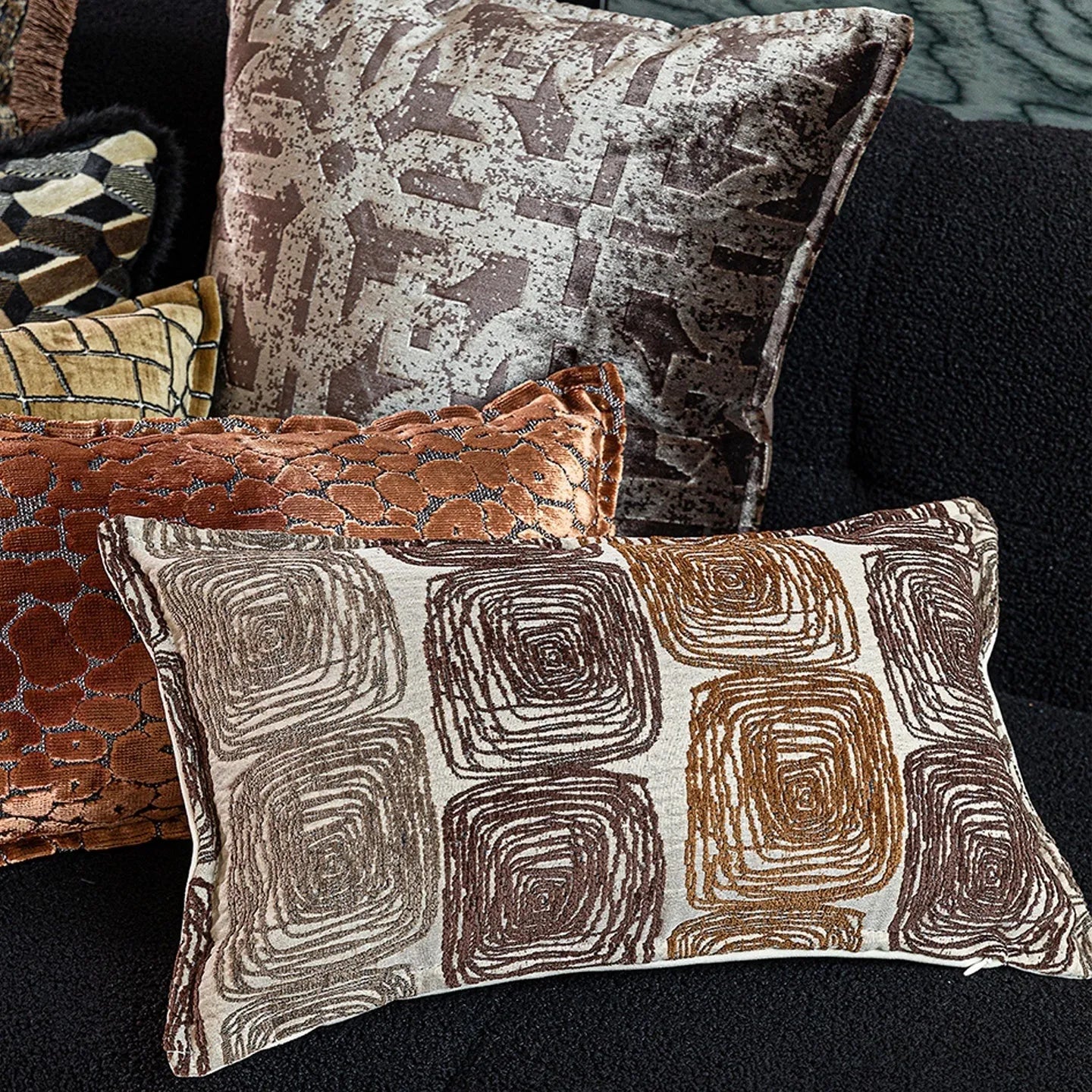 Cream and coffee coloured abstract coil pattern square and rectangular polyester cushion covers.
