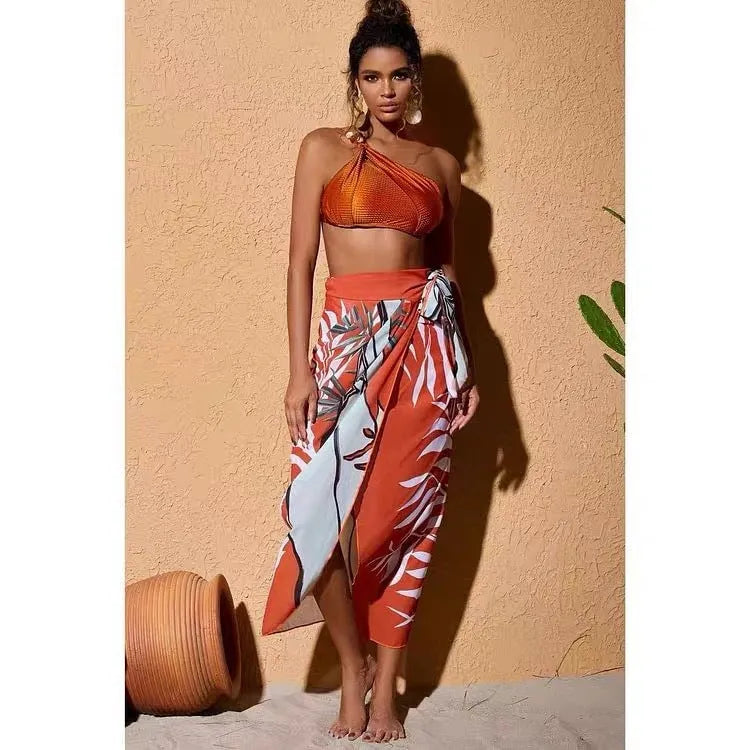 Women's brown high waist bikini with a sheer chiffon dress overlay attached.