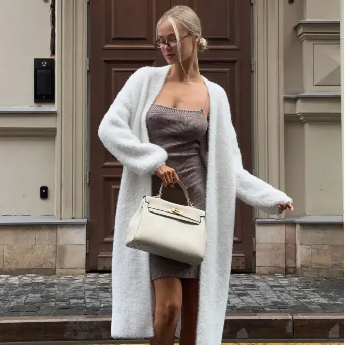 White oversized knitted cardigan jacket with long sleeves on a model.
