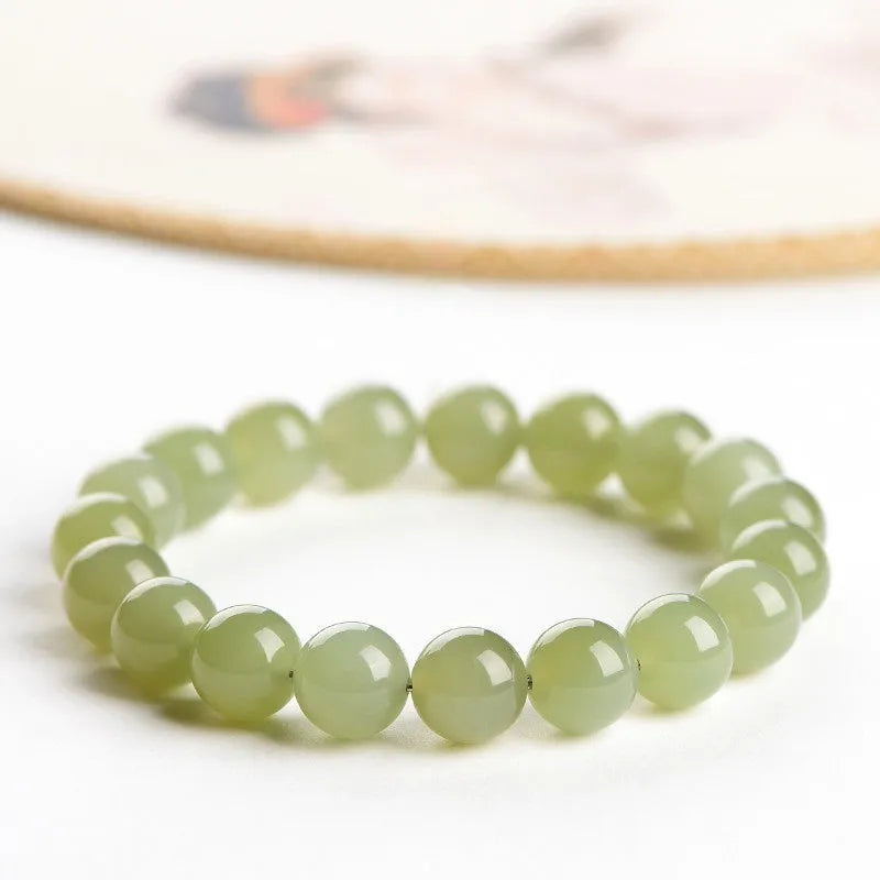 Polished Hetian jade bead bracelet in light or deep clear water colour on a wrist.