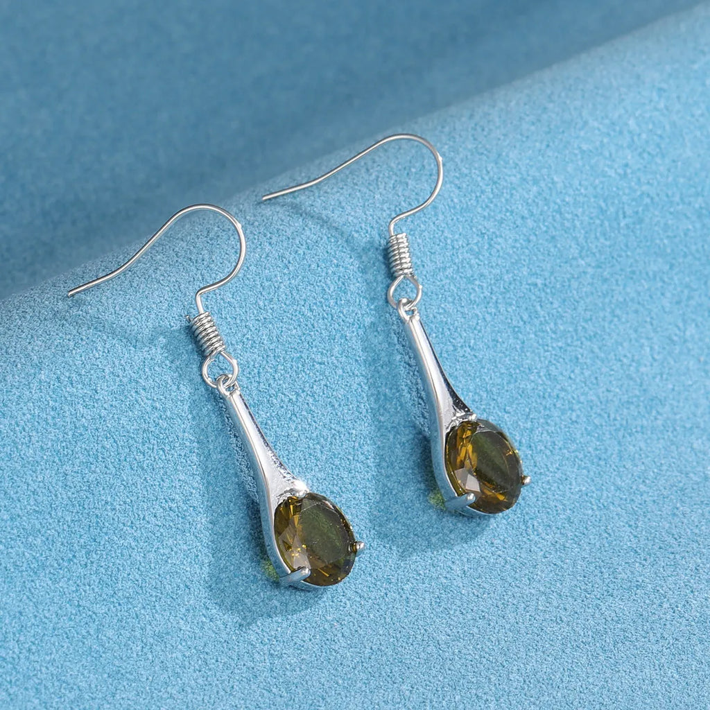 Olive green topaz coloured drop-shaped fashion earrings with a retro style on a white background.