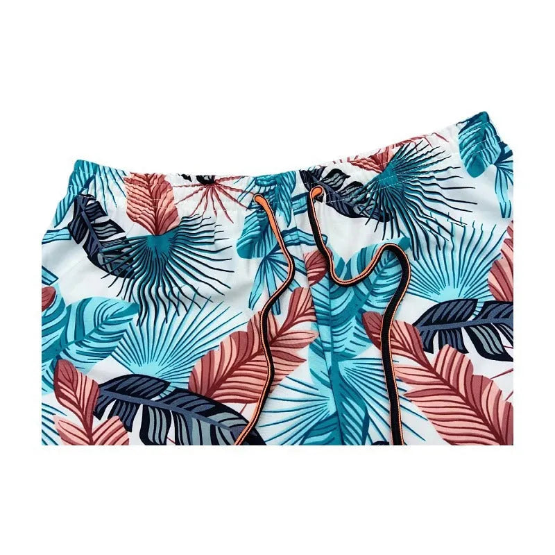 Men's cropped swimming trunks in a blue leaf pattern, made from polyester and spandex blend.