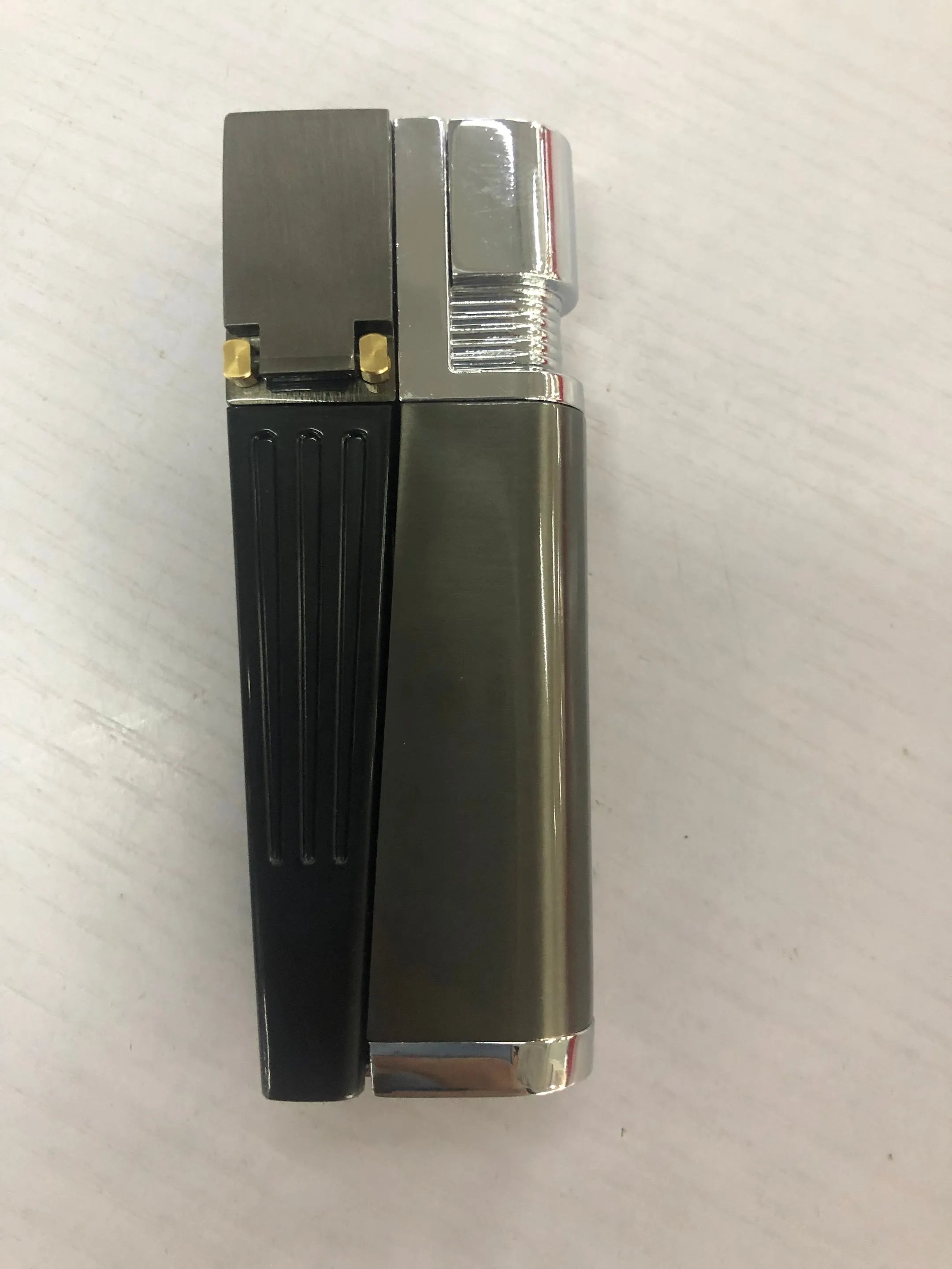 Silver foldable metal pipe lighter in open position showing flame mechanism and storage compartment.